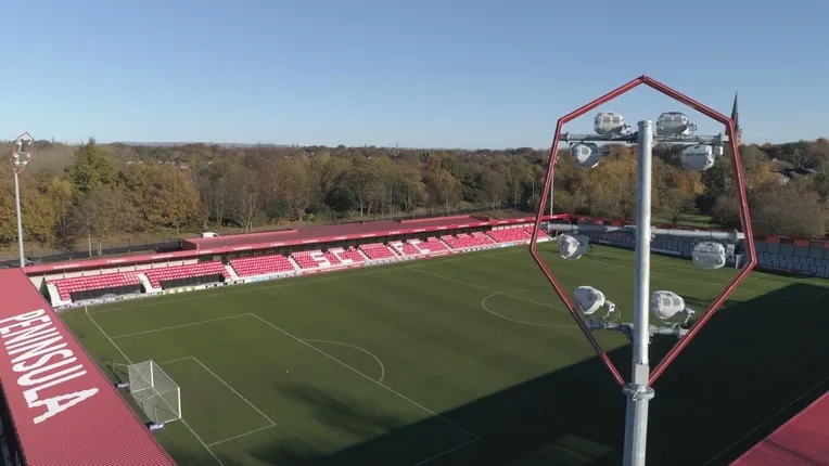 Cận cảnh dàn đèn pha hiện đại rực sáng tại sân Peninsula Stadium, Moor Lane, biểu tượng cho ánh sáng hy vọng và những đêm đấu kịch tính của Salford City FC trong hành trình chinh phục các giải đấu Anh.