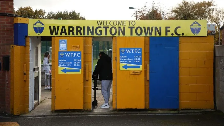 Cổng vào sân Cantilever Park với lối vào khán đài chính, sẵn sàng đón các cổ động viên Warrington Town FC