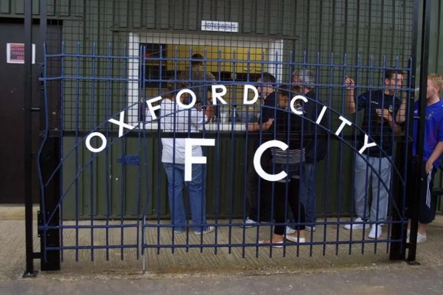 Hàng rào sân vận động Oxford City FC tại Court Place Farm, nơi chứng kiến bao pha bóng 'kinh điển' và những câu chuyện về sự nghiệp thăng trầm của 'The Hoops'