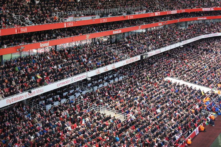 Khán đài sân Emirates với những hàng ghế đỏ trắng, không khí sôi động của Pháo thủ